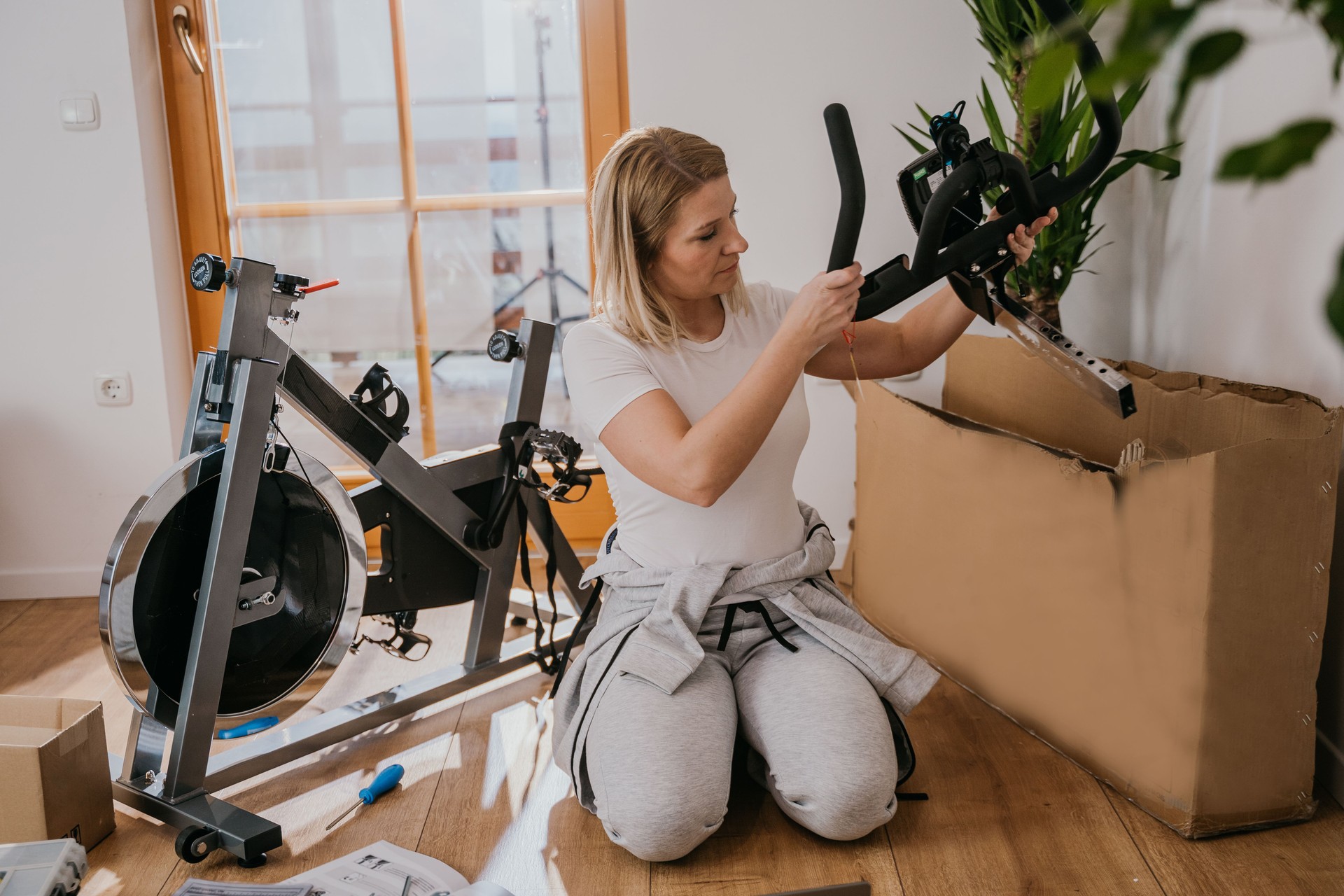 Woman unpacking stationary bicycle